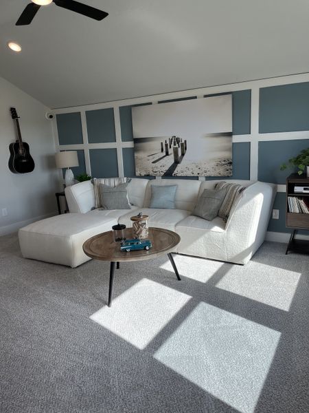 A cozy living area featuring a plush sectional, modern artwork, and soft lighting accents. A cozy living area featuring a plush sectional, modern artwork, and soft lighting accents.