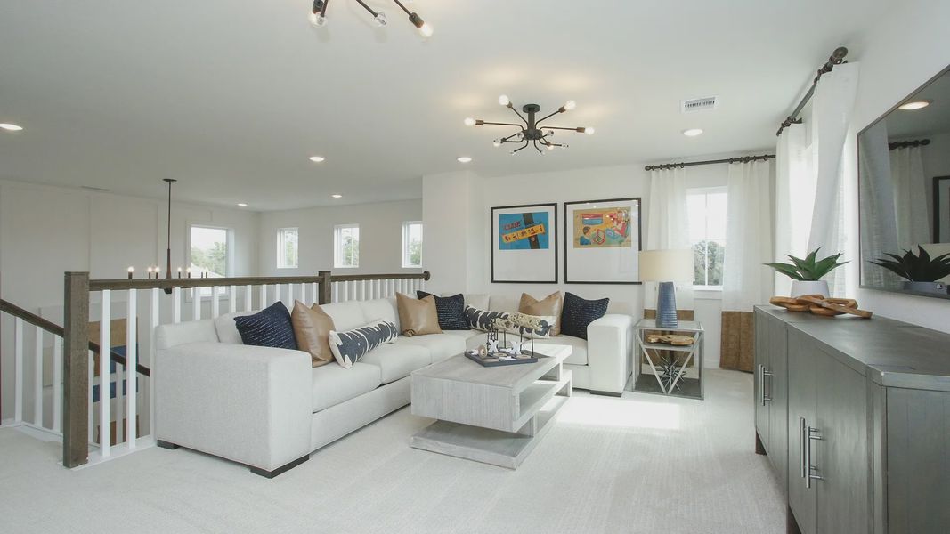 Discover the chic elegance of a spacious living room featuring plush seating, bespoke lighting, and rich textures in Colony at Pinehurst.