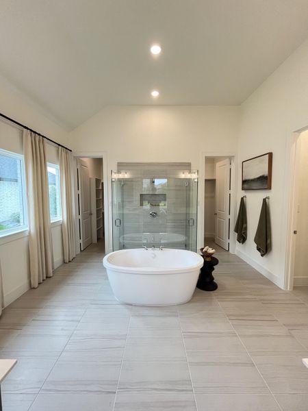 A luxurious bathroom featuring a freestanding tub, glass-enclosed shower, and large windows for natural light. A luxurious bathroom featuring a freestanding tub, glass-enclosed shower, and large windows for natural light.