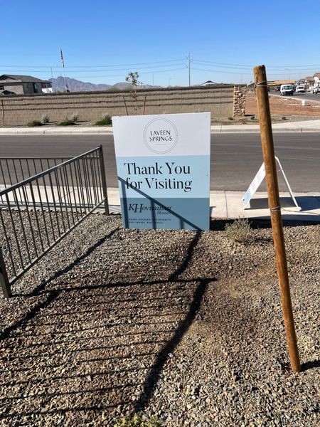 A welcoming sign at Laveen Springs by K. Hovnanian® Homes in Phoenix, AZ, surrounded by a scenic, sunny backdrop.