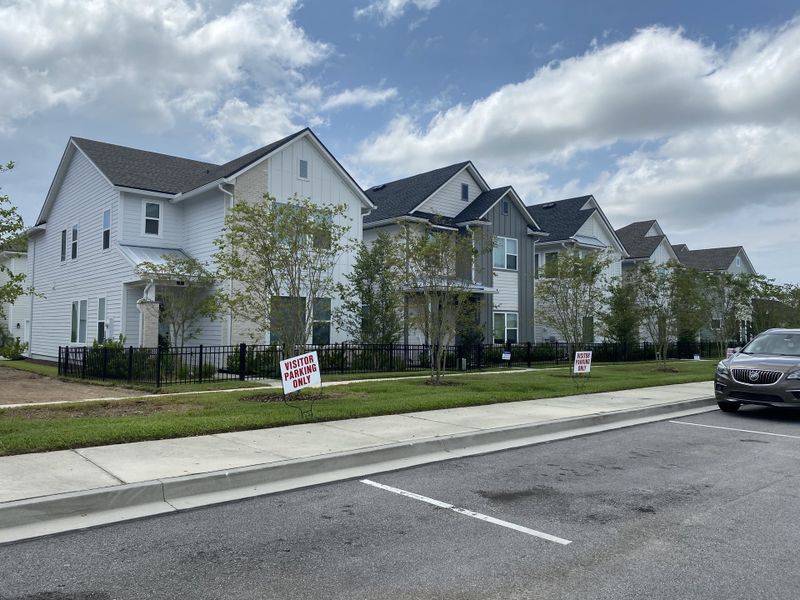 A row of modern white homes with fenced yards in Granville at eTown 34' by David Weekley Homes (Jacksonville, FL). A row of modern white homes with fenced yards in Granville at eTown 34' by David Weekley Homes (Jacksonville, FL).