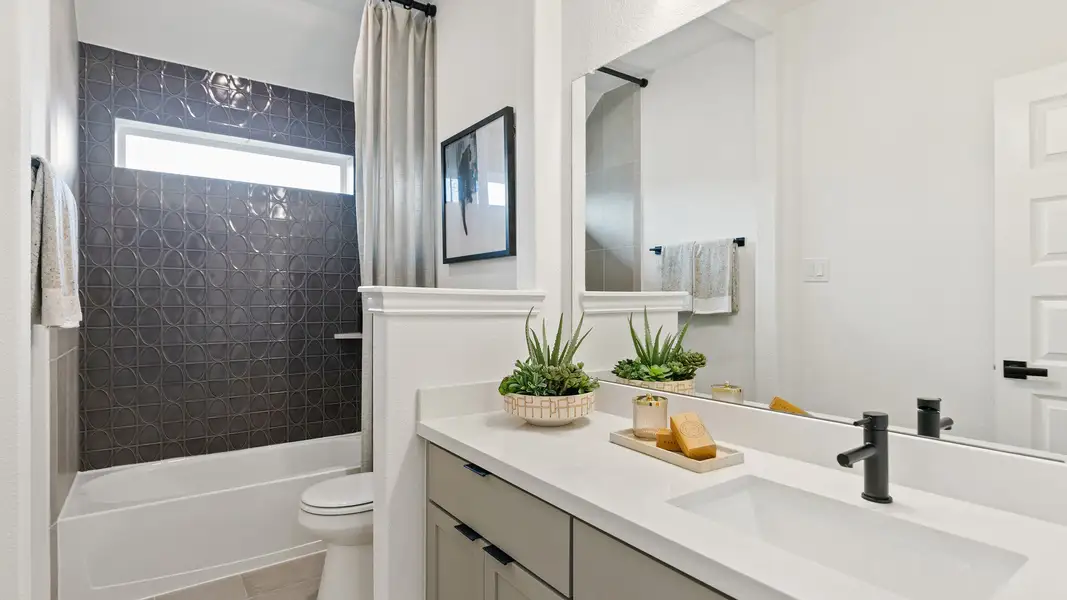 Luxurious bathroom features geometric tile and sleek design elements in Park at Eldridge.