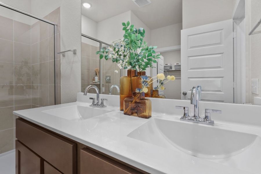 A bathroom with a sink and a shower unit.