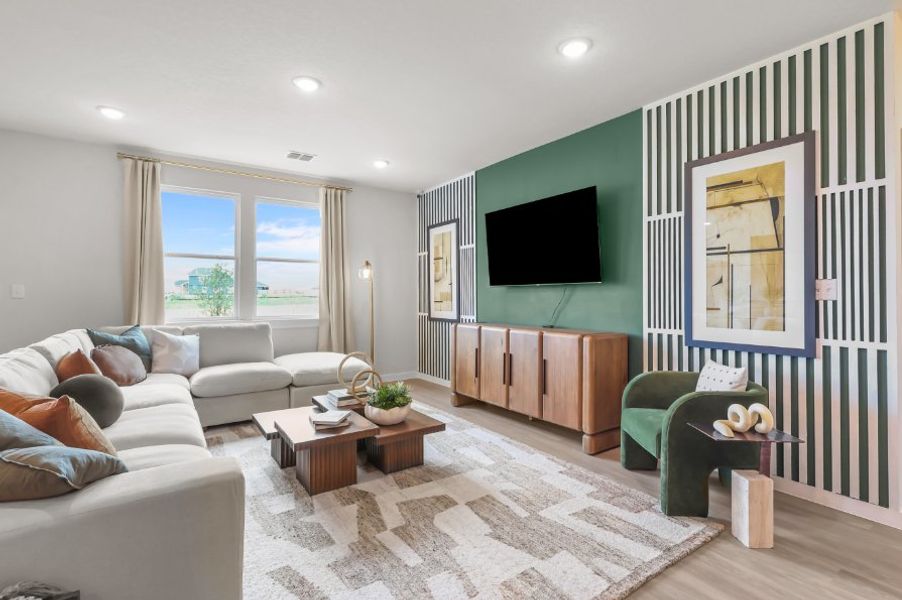 A living room with a tv and couches. A living room with a tv and couches.
