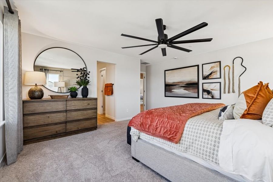 A bedroom with a bed and a fan.