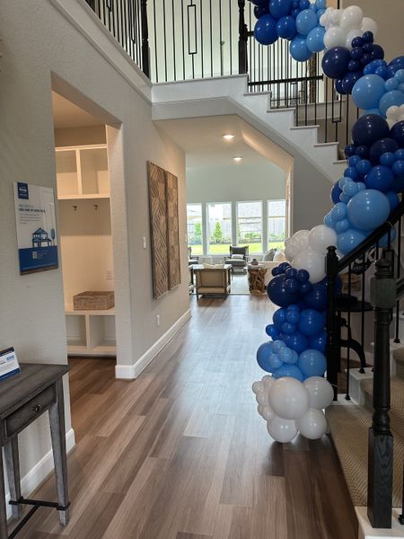 An elegant entryway with a stylish staircase adorned with blue and white balloons, featuring modern décor and ample natural light. An elegant entryway with a stylish staircase adorned with blue and white balloons, featuring modern décor and ample natural light.
