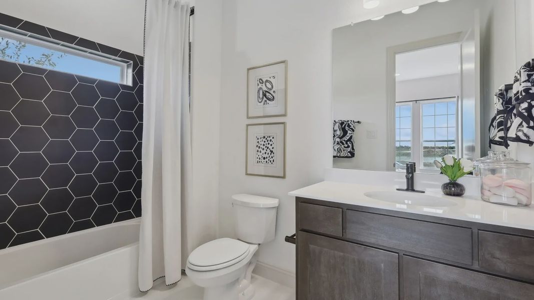 Elegant bathroom with bold hexagonal tile and stylish vanity. Expansive window views enhance Westside Preserve living.