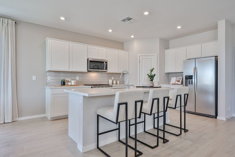 A kitchen with white cabinets.