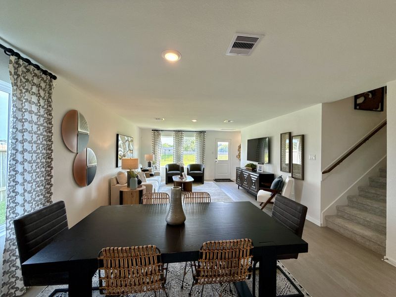 An elegant living-dining area with modern decor, cozy seating, and ample natural light.