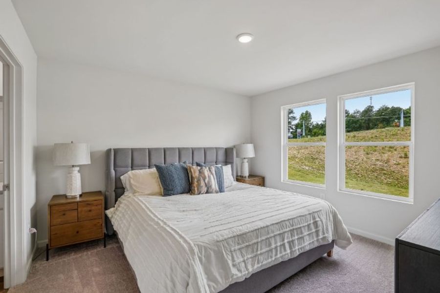 A bedroom with a large window.