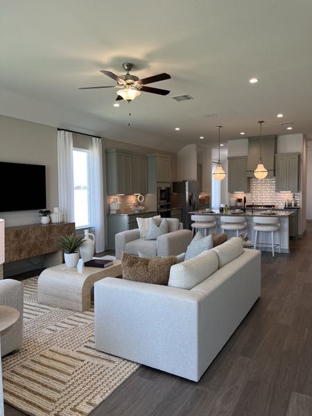 A modern living area with elegant gray cabinetry, cozy seating, and a bright and airy open-concept design.