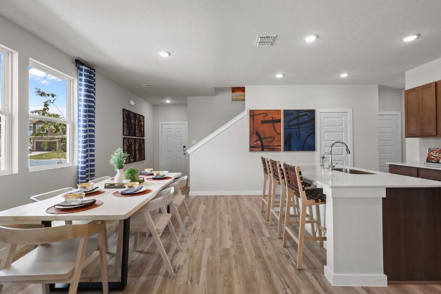 A kitchen with a table and chairs.