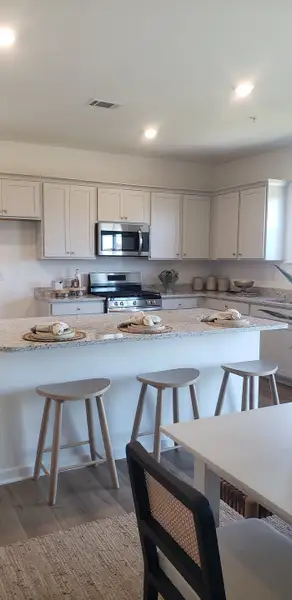 A modern kitchen with sleek cabinets, granite countertops, and a central island with seating for casual dining.