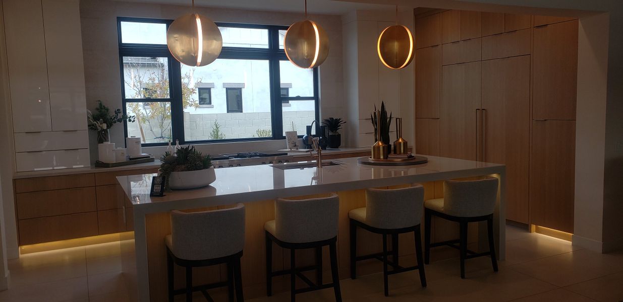 A modern kitchen featuring a spacious island, chic pendant lights, and sleek cabinetry for a contemporary feel.