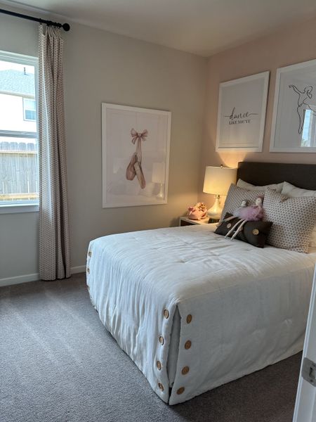 A cozy bedroom featuring a plush bed, artistic ballerina-themed decor, and soft, neutral tones for a serene ambiance. A cozy bedroom featuring a plush bed, artistic ballerina-themed decor, and soft, neutral tones for a serene ambiance.