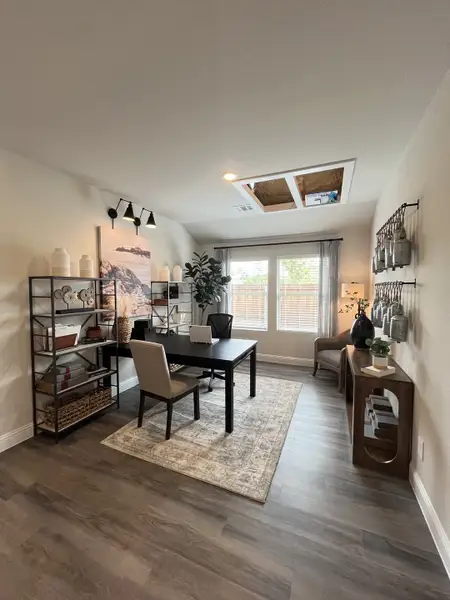 A contemporary home office with dark wood floors, modern shelving, and soft natural light through large windows. A contemporary home office with dark wood floors, modern shelving, and soft natural light through large windows.