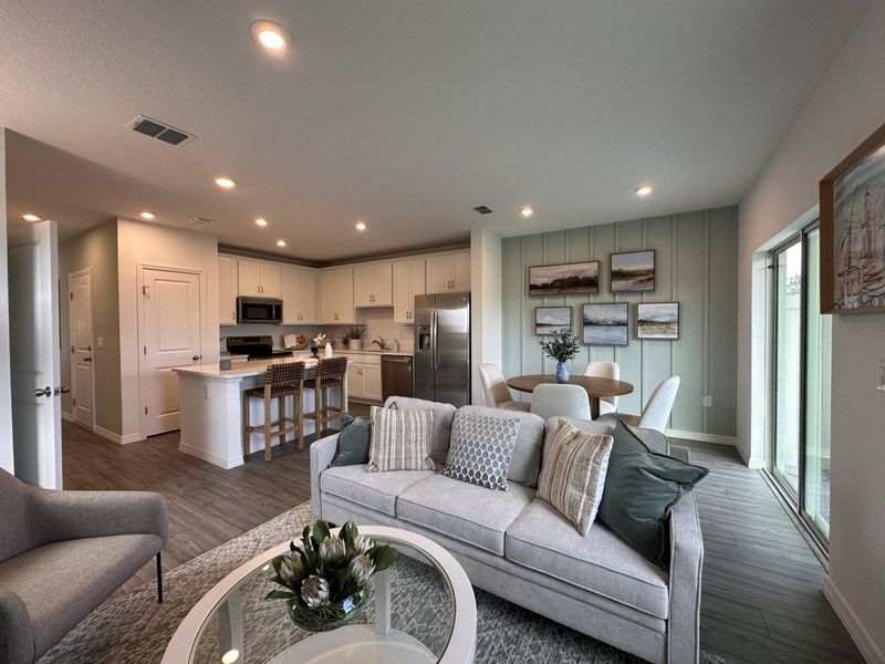 A modern open-plan living area with a cozy sofa, stylish kitchen, and elegant dining space.