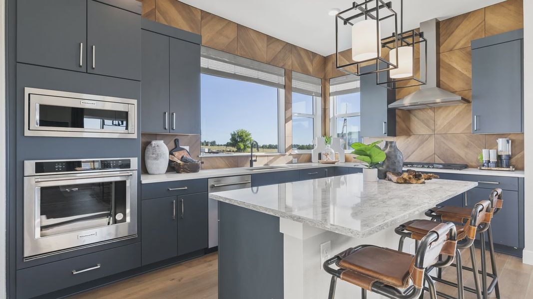 Experience elegance in Dillon Pointe's kitchen with marble counters, chic navy cabinets, and panoramic views. Experience elegance in Dillon Pointe's kitchen with marble counters, chic navy cabinets, and panoramic views.