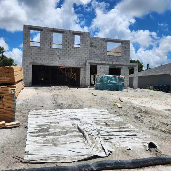 A modern two-story home under construction in Palm Bay by D.R. Horton, featuring a block structure and spacious layout (Palm Bay, FL).