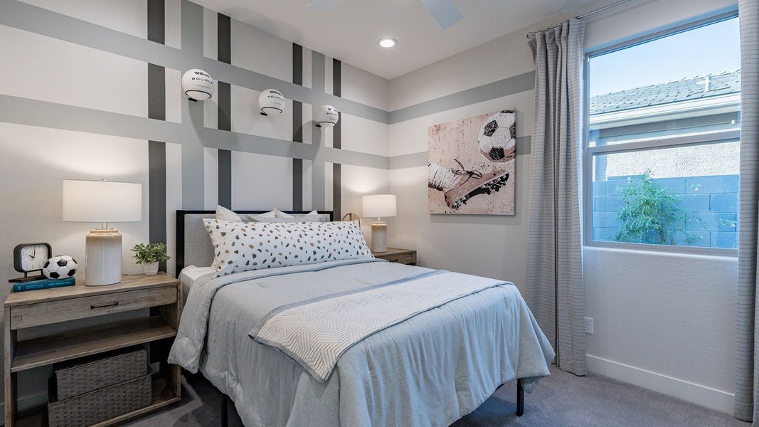 Sleek striped walls and plush bedding create a modern oasis in The Villas at Mystic community.