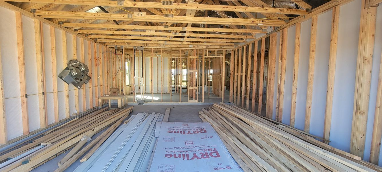 A construction site showcasing wooden framing, drywall materials, and beams, revealing future interior possibilities.
