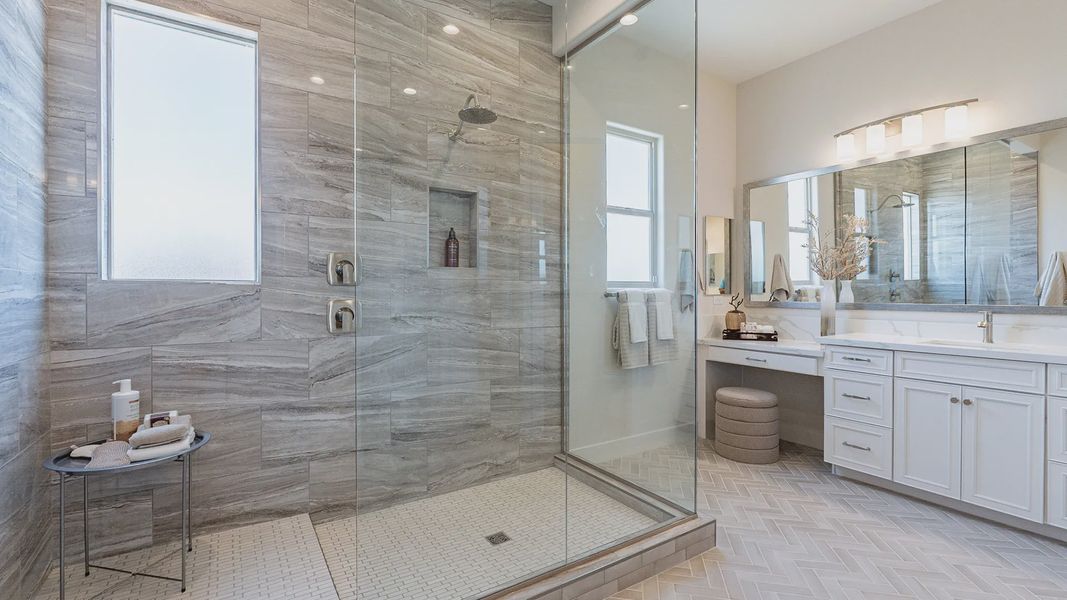 Experience opulence with marble tile, a spacious glass shower, and elegant vanity in Windrose community.