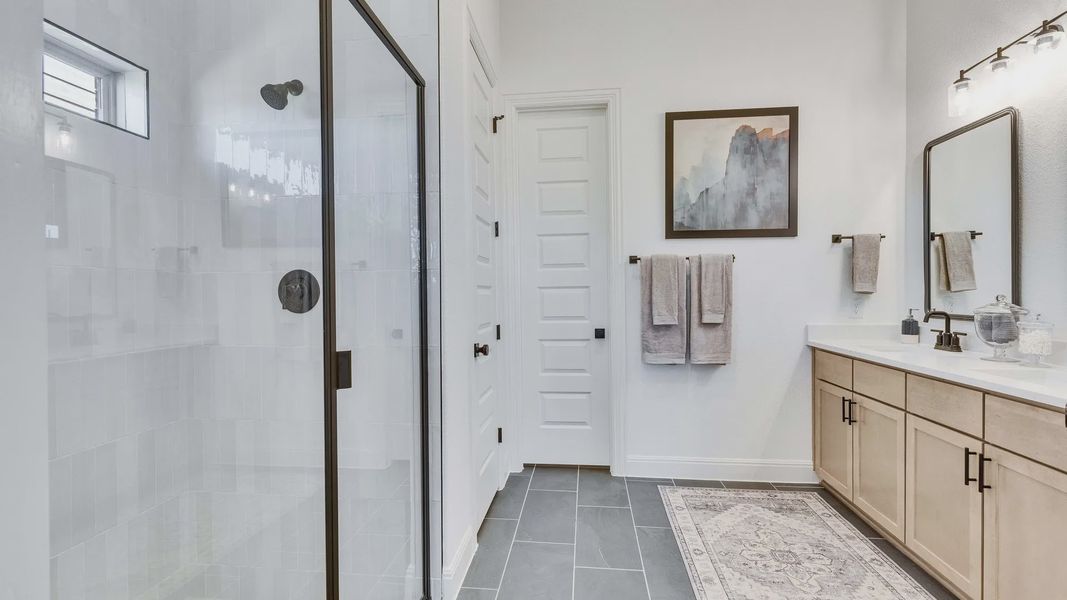 Luxurious Briarwood bathroom featuring a glass-enclosed shower and sophisticated black fixtures.