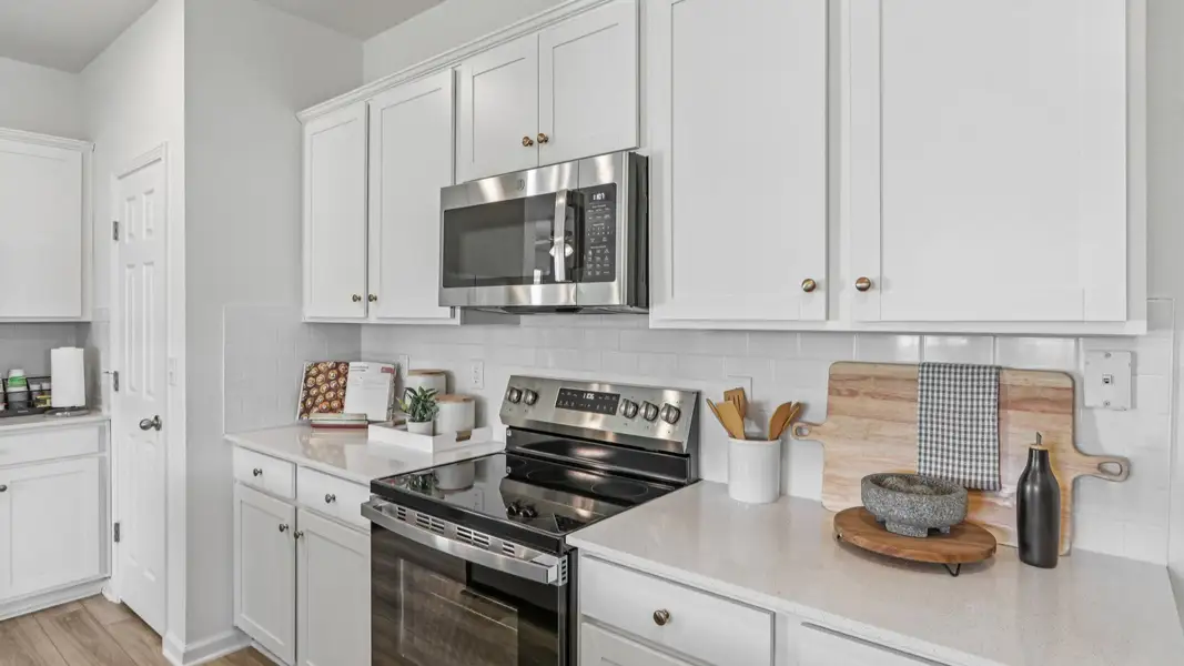Luxurious kitchen in Panther Creek boasts sleek white cabinetry, marble island, and premium stainless appliances. Luxurious kitchen in Panther Creek boasts sleek white cabinetry, marble island, and premium stainless appliances.