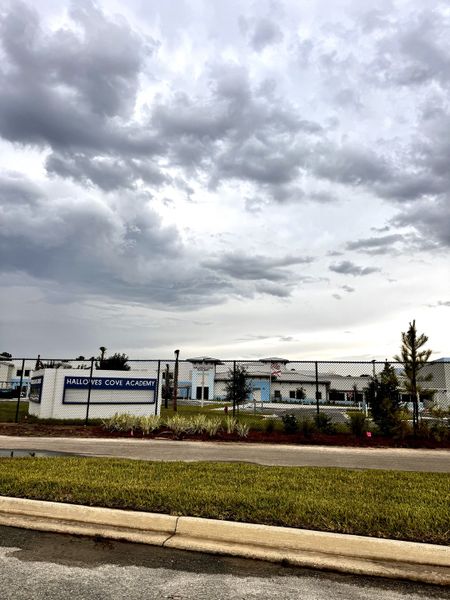 Modern educational facility with a fenced yard under dramatic skies in RiverTown - Springs by Mattamy Homes, St. Johns, FL. Modern educational facility with a fenced yard under dramatic skies in RiverTown - Springs by Mattamy Homes, St. Johns, FL.
