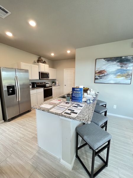 A modern kitchen with granite countertops, stainless steel appliances, and a stylish breakfast bar with seating for three. A modern kitchen with granite countertops, stainless steel appliances, and a stylish breakfast bar with seating for three.