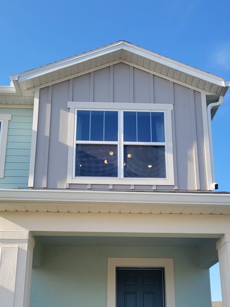 Charming modern facade in muted tones with a gabled roof, featured at Hamlin Pointe by Dream Finders Homes (Winter Garden, FL).