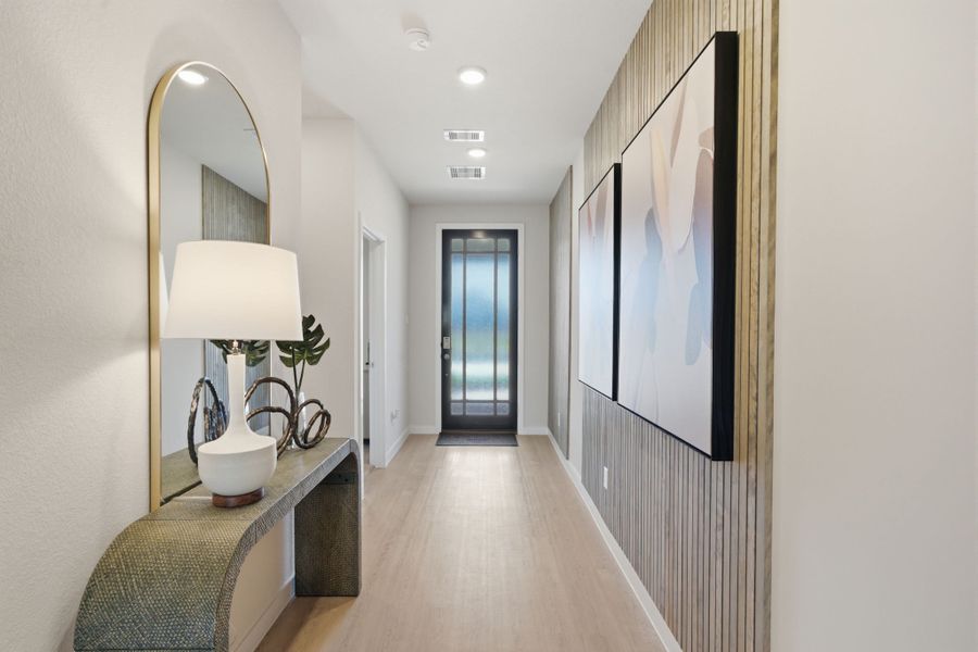 A hallway with a mirror and a lamp. A hallway with a mirror and a lamp.