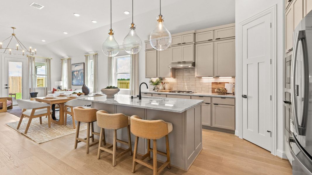 Modern kitchen showcasing neutral beige cabinetry, sleek countertops, and a bright, open design in Azalea community.