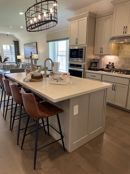 A modern kitchen with a spacious island, sleek cabinetry, and stylish pendant lighting. A modern kitchen with a spacious island, sleek cabinetry, and stylish pendant lighting.