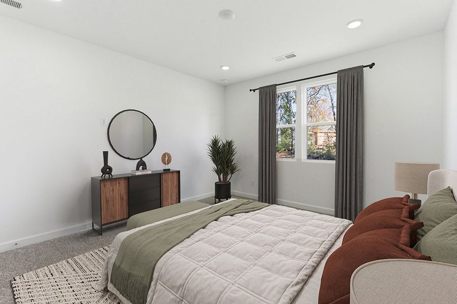 A bedroom with a bed and a mirror.