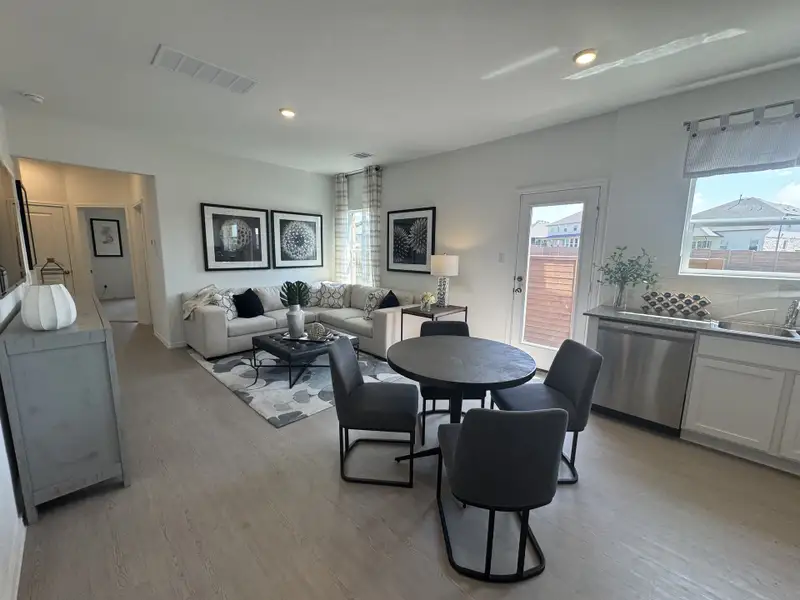 Open-concept living area featuring cozy seating, modern decor, and ample natural light from large windows.