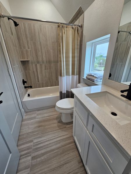 A modern bathroom with wood-style tiled shower, sleek white vanity, and neutral tones for a serene ambiance.