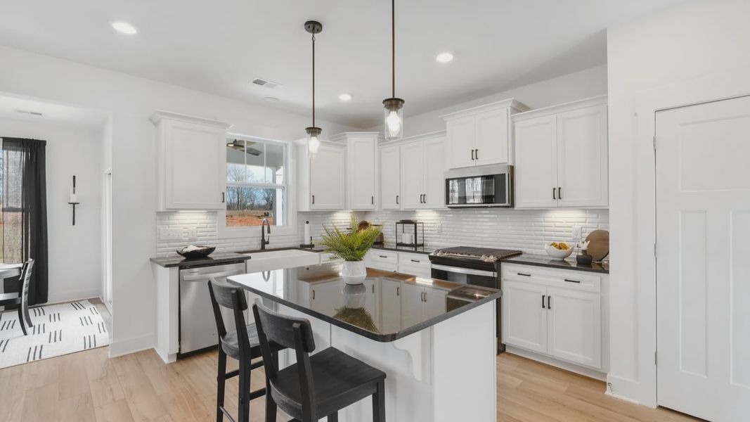 Black and white kitchen with granite countertops at Mulberry Estates by DRB Homes in Simpsonville, South Carolina