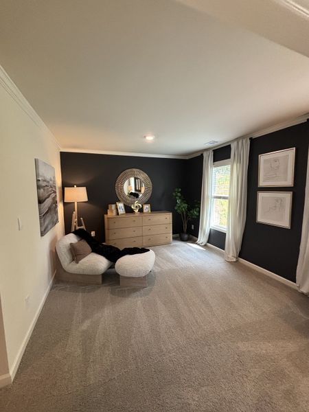 A cozy living space with plush seating, a sleek dresser, and elegant wall decor in a modern palette.