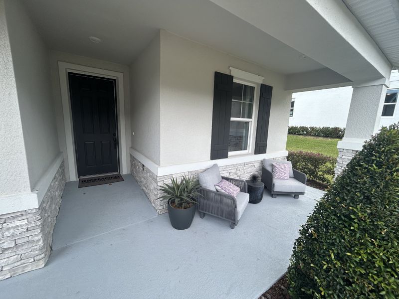 A cozy front porch with stone accents and plush seating. Seasons at Wekiva Ridge by Richmond American Homes (Mount Dora, FL). A cozy front porch with stone accents and plush seating. Seasons at Wekiva Ridge by Richmond American Homes (Mount Dora, FL).