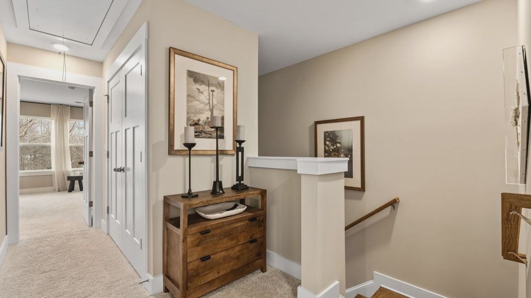 Carpeted hallway with elevated ceilings in two story townhome at Hickory Heights by DRB Homes in Downtown Greenville, SC