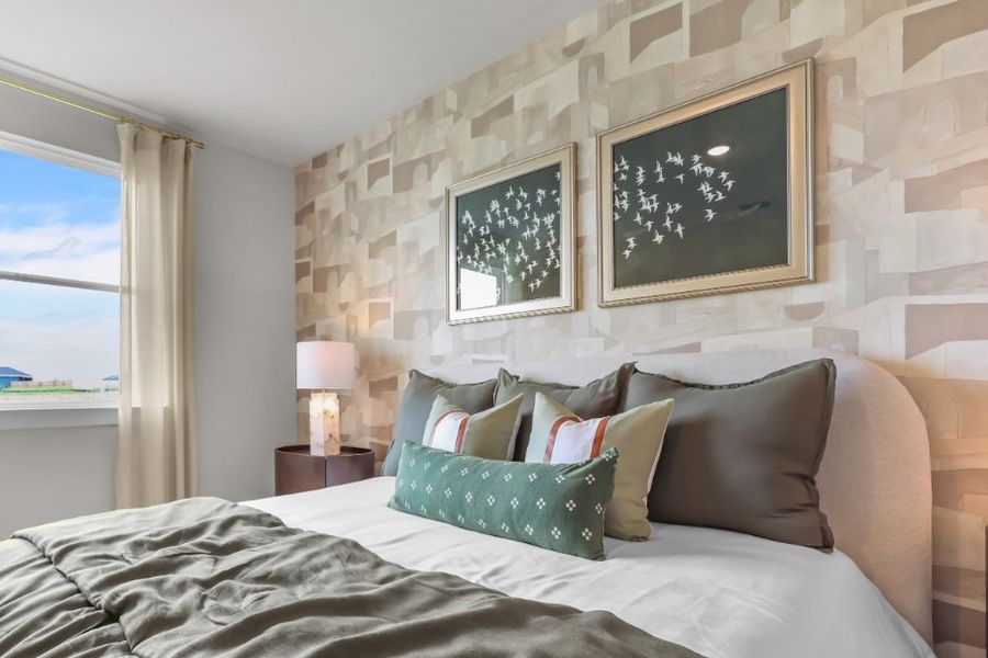 A bed with pillows and a lamp. A bed with pillows and a lamp.