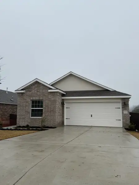 A modern brick home with a spacious driveway in Lively Ranch: Claremont Collection by Lennar (Georgetown, TX).
