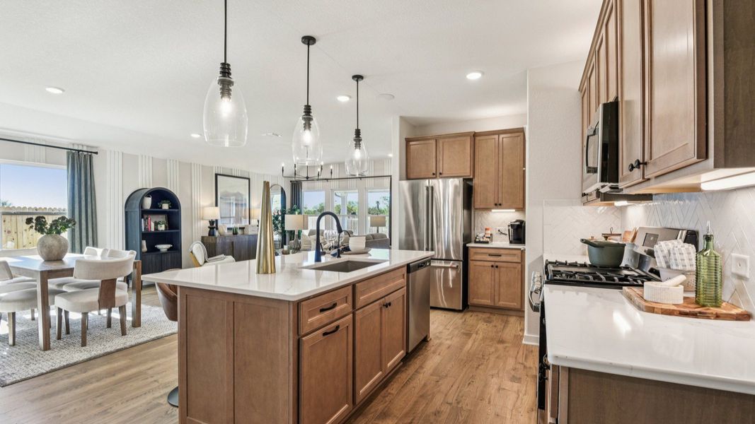The kitchen features 42 inch wood cabinetry with industrial style pendant lighting above the center island The kitchen features 42 inch wood cabinetry with industrial style pendant lighting above the center island