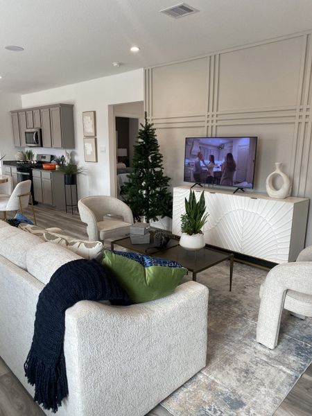 A chic living room with neutral tones, stylish panel wall decor, and a cozy sofa setup.