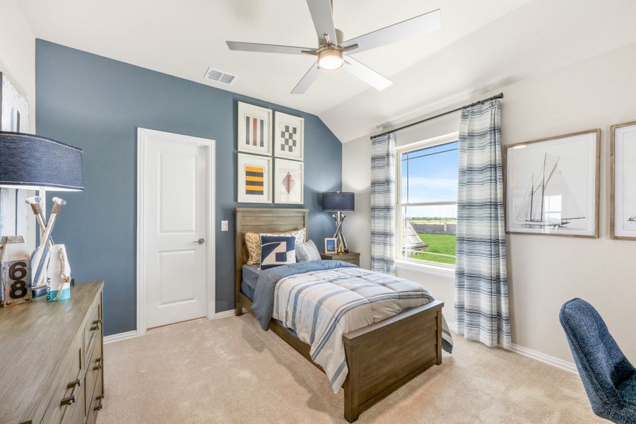 Children's bedroom with blue accent wall, wood bed frame, ceiling fan, and vaulted ceiling Children's bedroom with blue accent wall, wood bed frame, ceiling fan, and vaulted ceiling