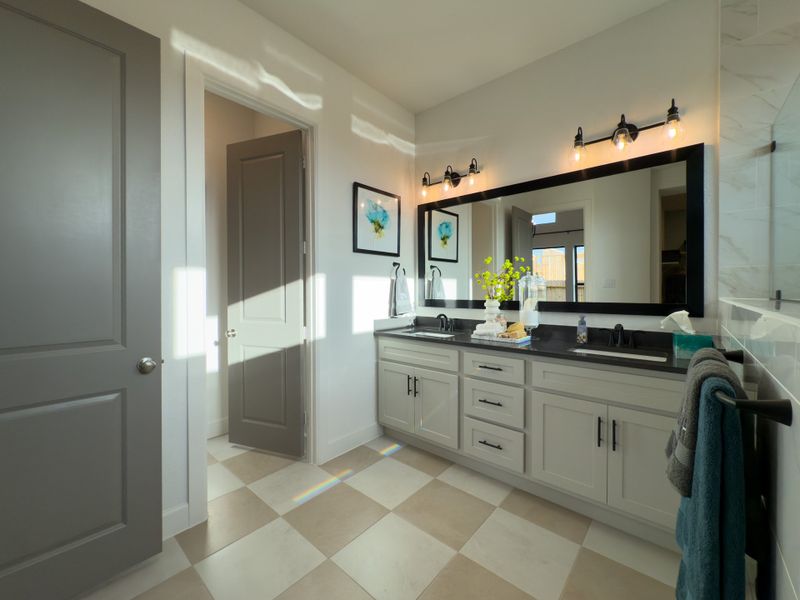 A bright bathroom with a double vanity, modern lighting, and decorative touches in a sleek, contemporary design. A bright bathroom with a double vanity, modern lighting, and decorative touches in a sleek, contemporary design.