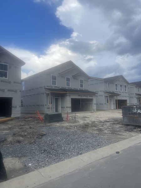 New construction two-story homes under a cloudy sky in Lindera Preserve at Cane Bay Plantation: Townhomes by Lennar (Summerville, SC).