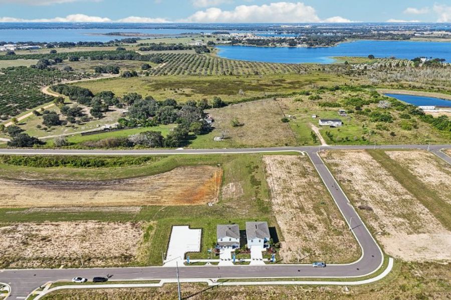 A road with a building and a body of water in the background.