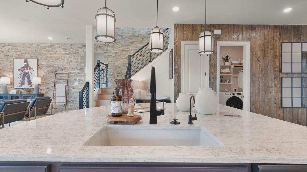 Open kitchen overlooking the great room with views of the staircase leading to the second floor.